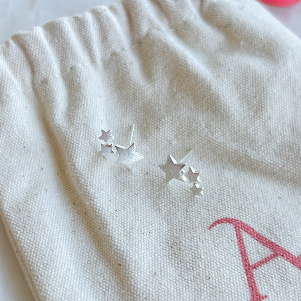 Aros de Plata Gante con diseño de estrella de mar y textura detallada en plata 925, exhibidos sobre una bolsa de tela Altapinta.