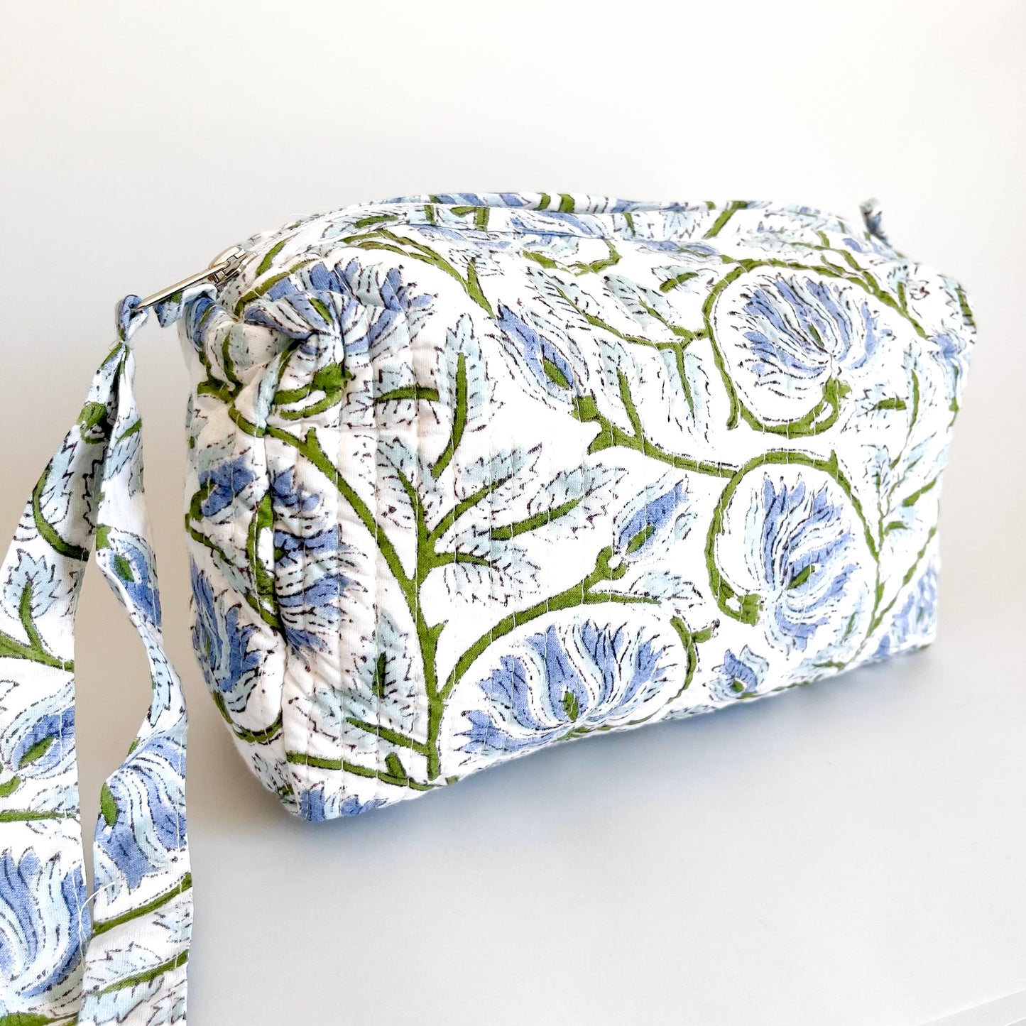 Estuche Begonia acolchado con estampado botánico, vista lateral con asa.