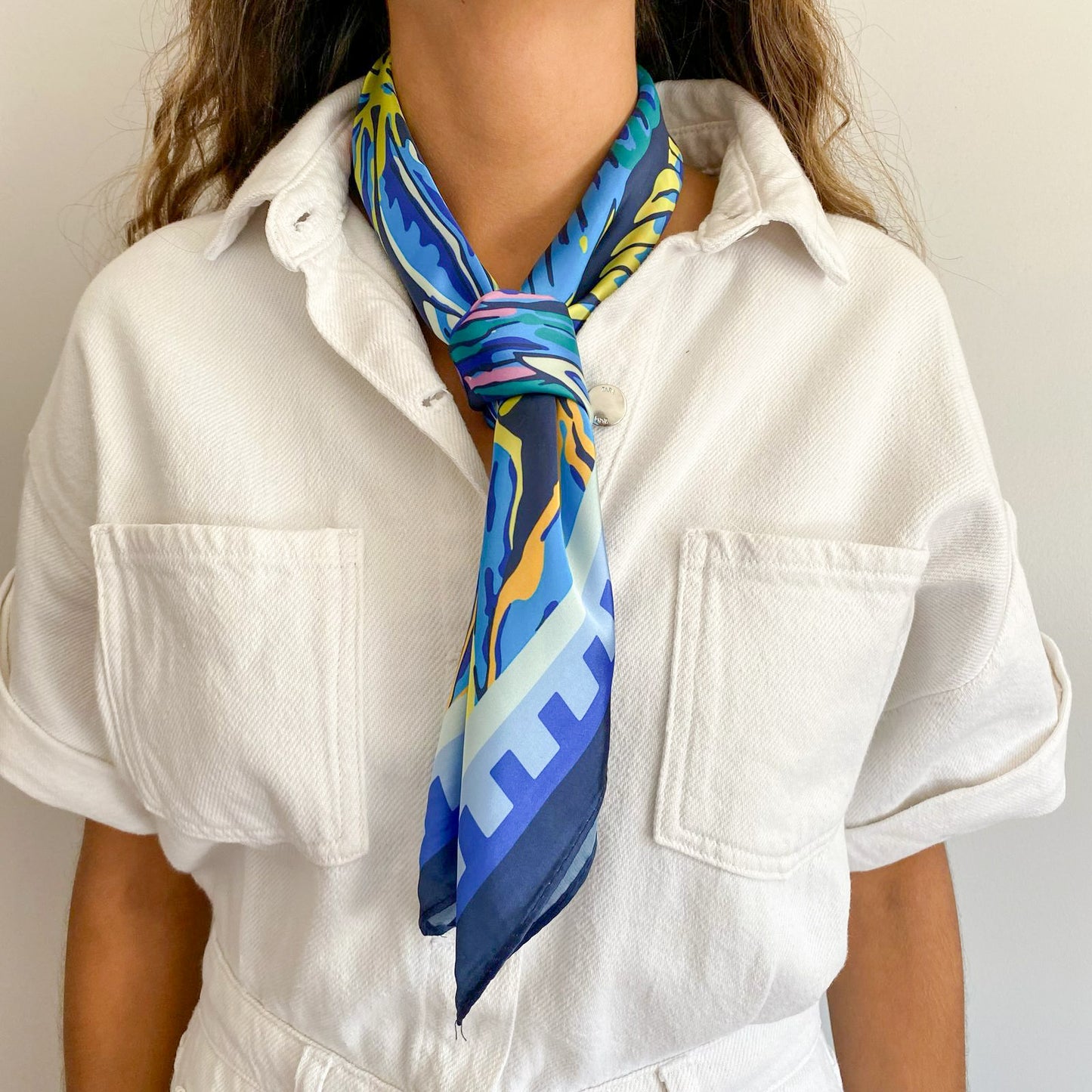 Mujer usando el pañuelo simil de seda capraia amarrado al cuello