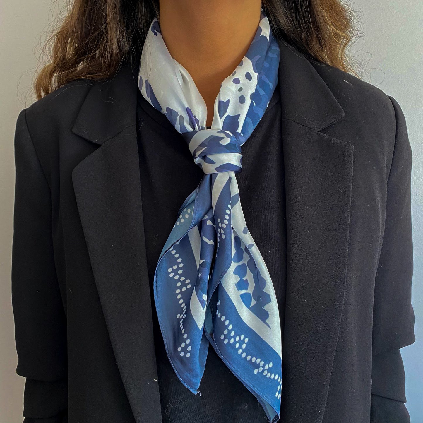 Mujer usando el pañuelo simil de seda eolia amarrado al cuello