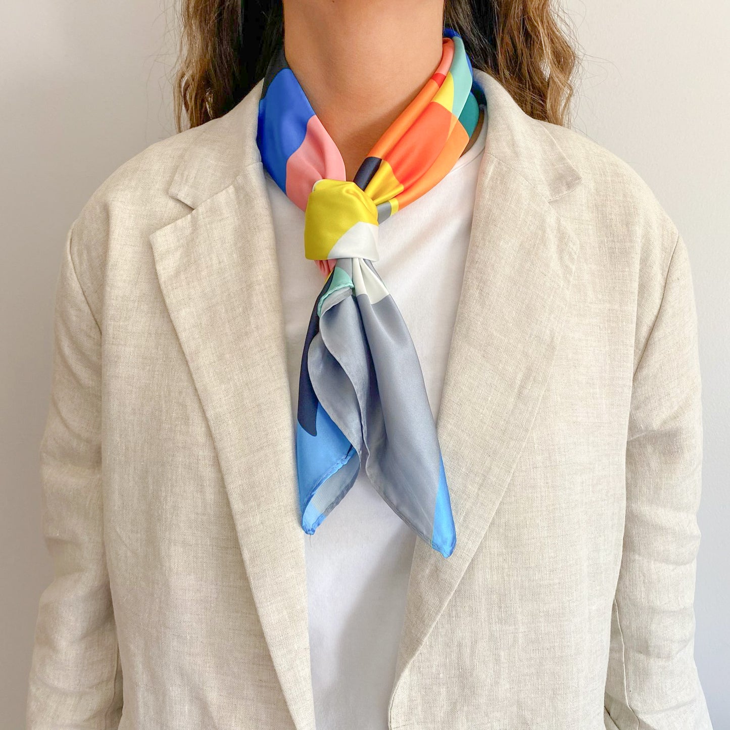 Mujer usando el pañuelo simil de seda montalto amarrado al cuello