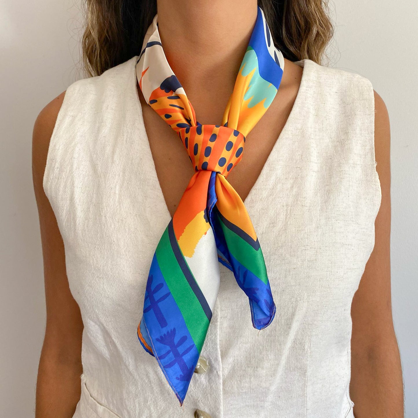 Mujer usando el pañuelo simil de seda nerea amarrado al cuello