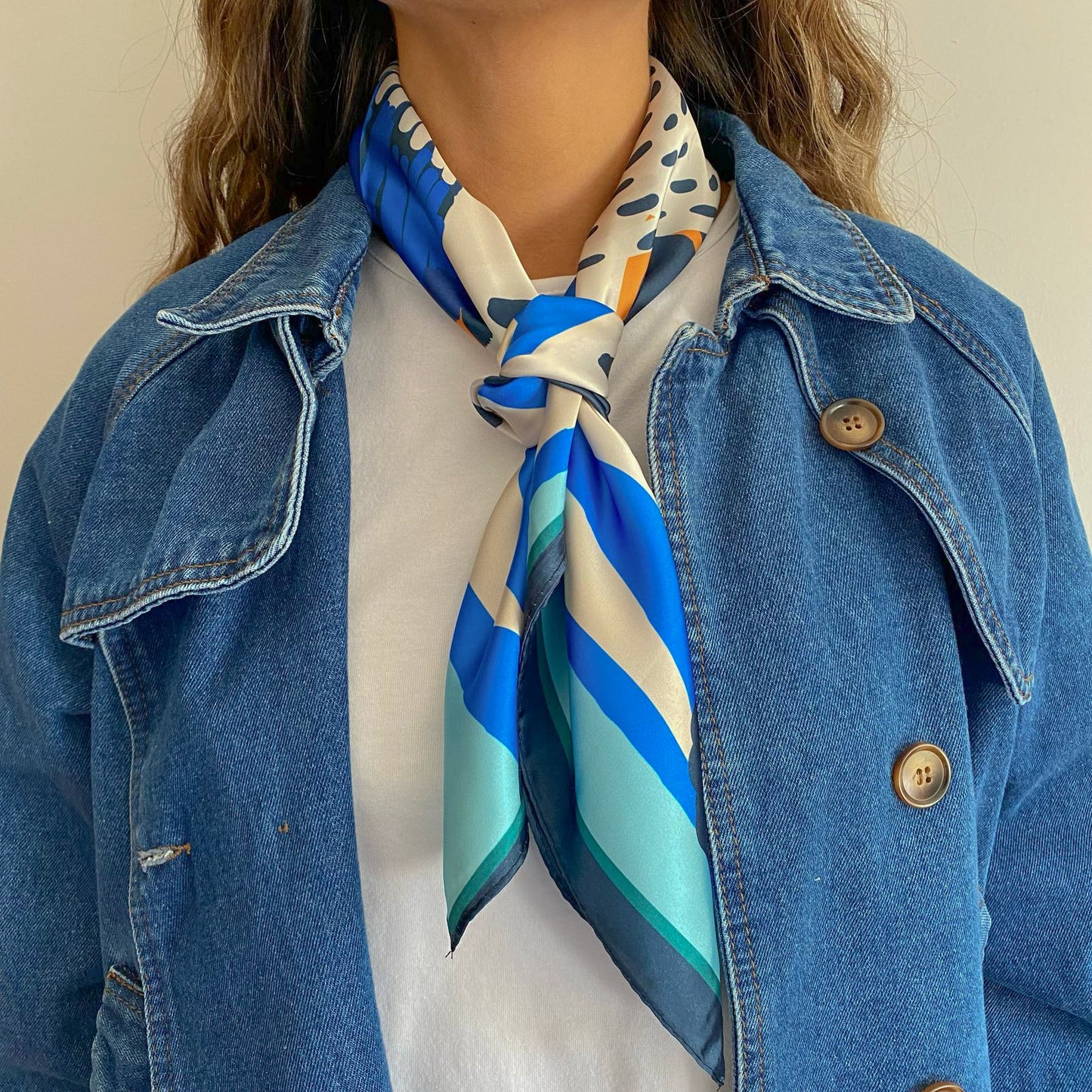 Mujer usando el pañuelo simil de seda selene amarrado al cuello