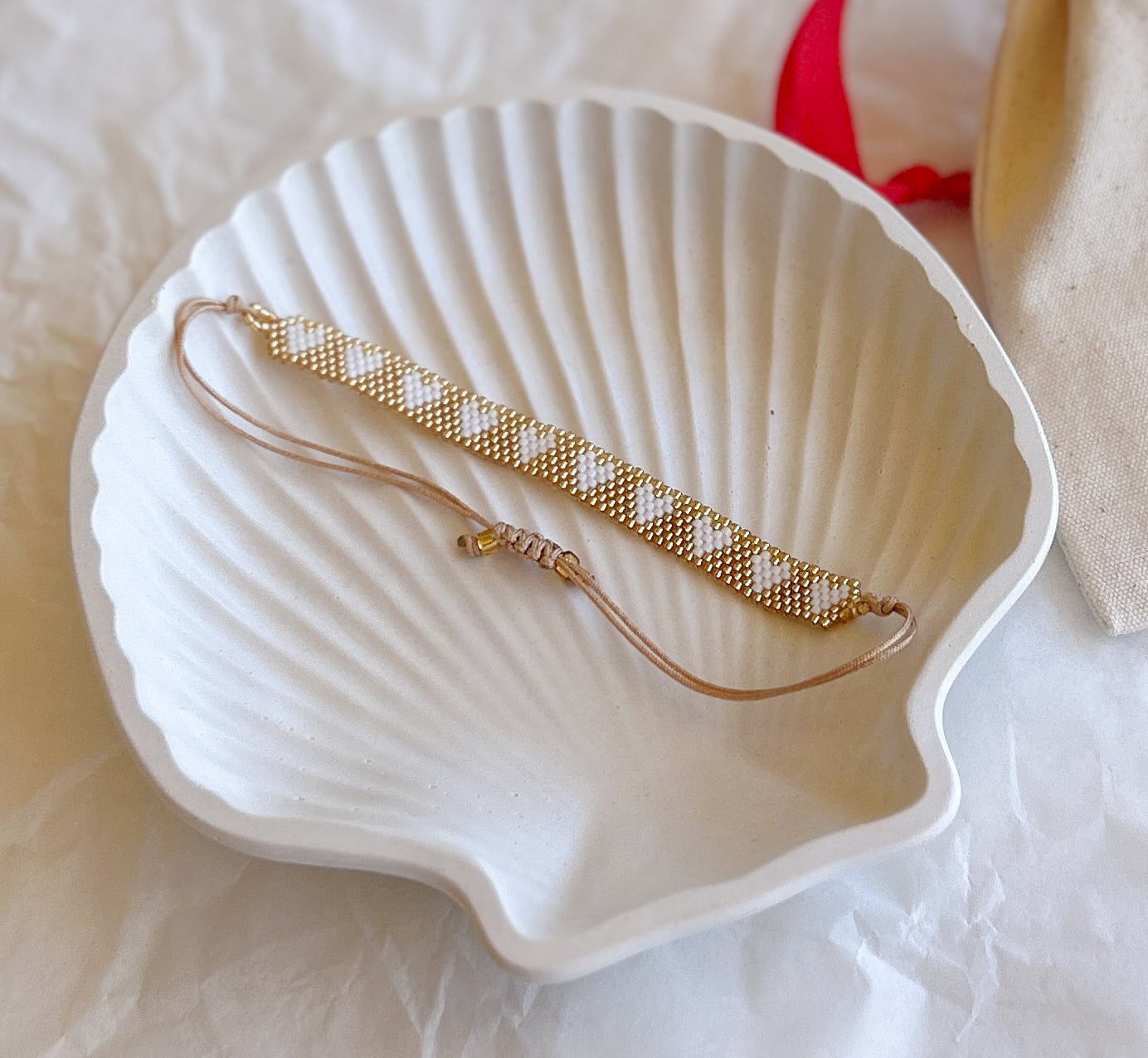 Pulsera Artesanal Corazones Ignacia en blanco y dorado, un diseño minimalista y sofisticado.