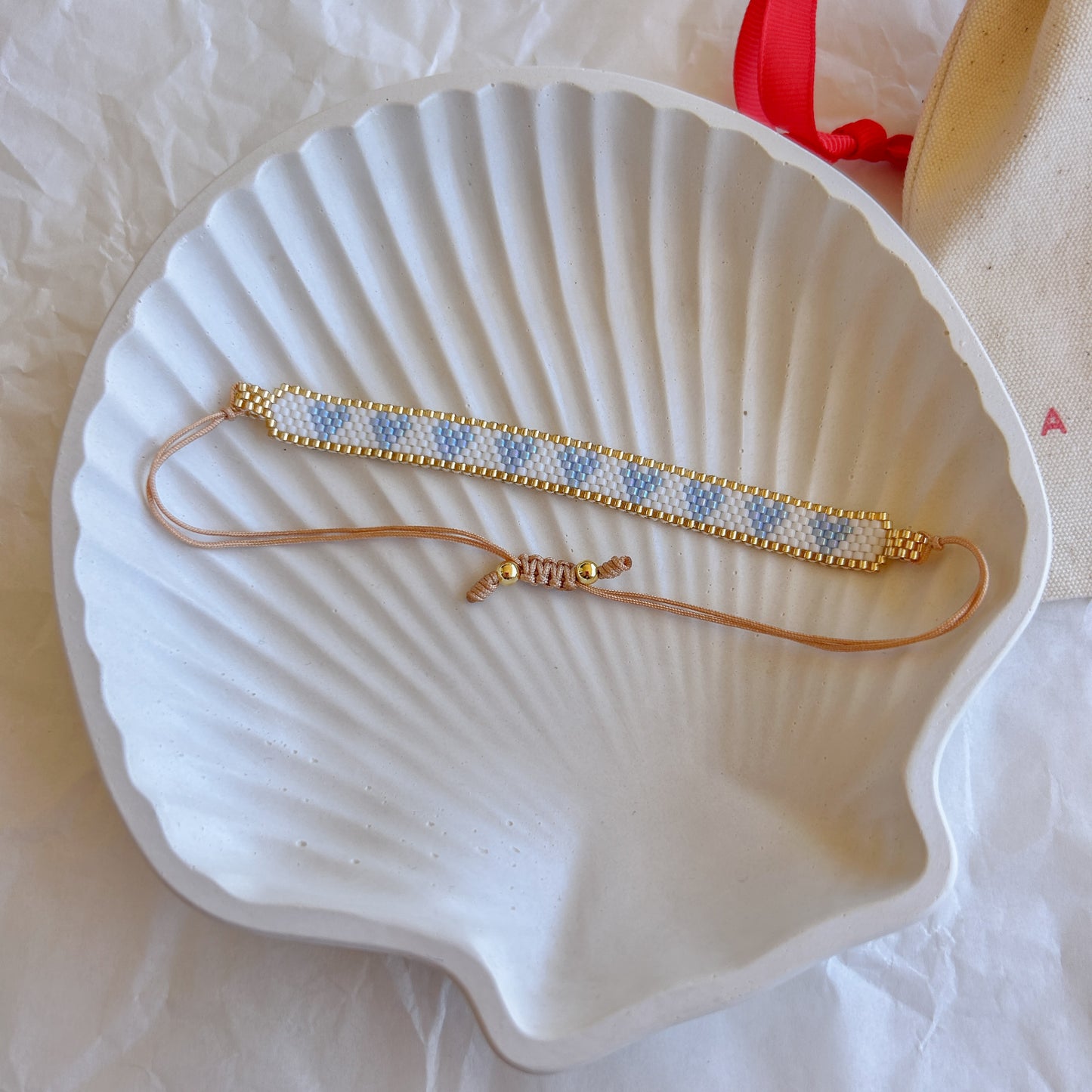 Pulsera Artesanal Corazones Josefina en azul celeste y dorado, con un diseño sutil.
