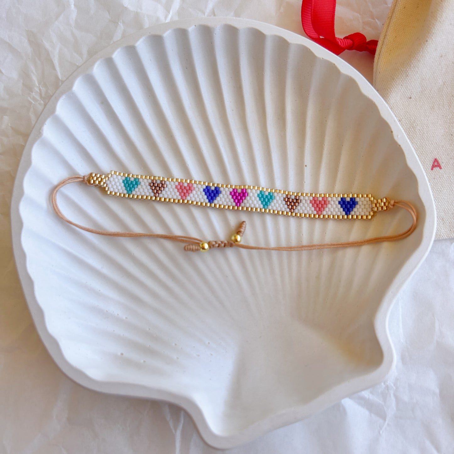 Pulsera Artesanal Corazones Josefina en tonos multicolor sobre dorado, ideal para un look vibrante.