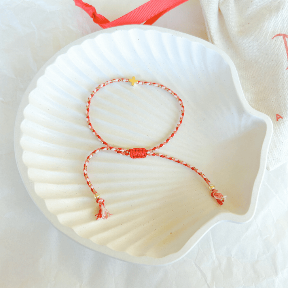 Pulsera artesanal religiosa Luisa en rojo y blanco con detalles dorados.
