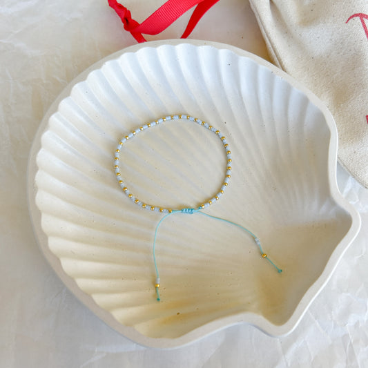 Pulsera Artesanal Simple Candelaria en color verde menta sobre concha blanca.