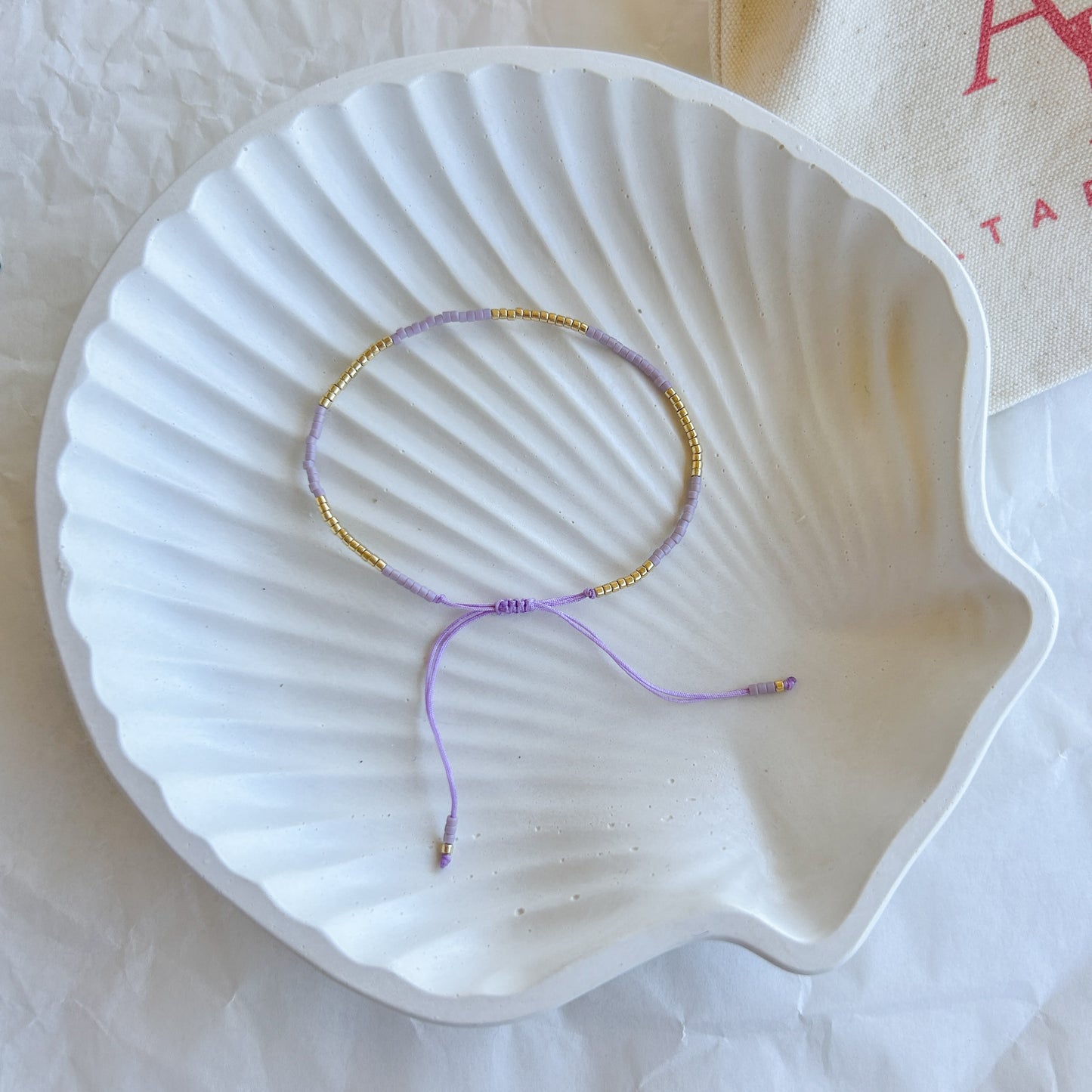 Pulsera artesanal simple Julieta color lila con cuentas doradas – Pulsera ajustable con un toque romántico y femenino, ideal para cualquier ocasión.