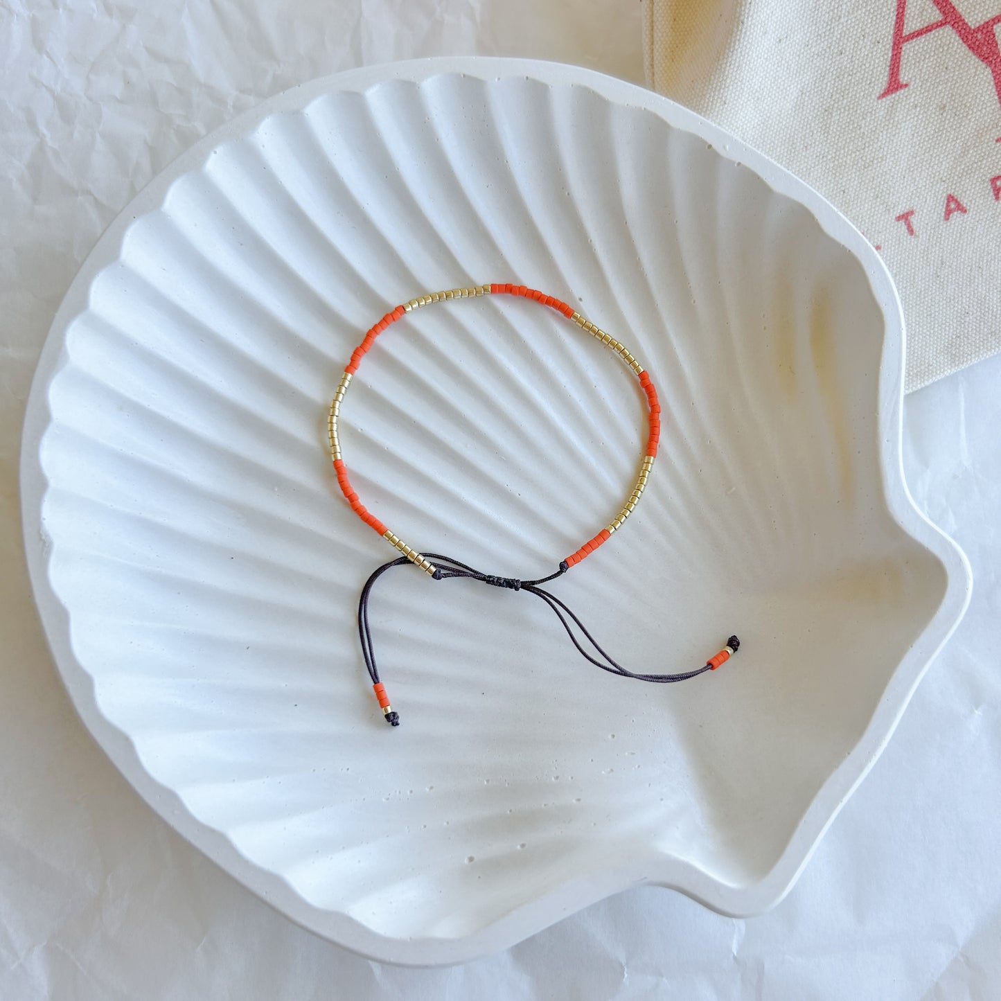 Pulsera artesanal simple Julieta color naranja con cuentas doradas – Pulsera vibrante y ajustable, perfecta para añadir un toque de energía a tu estilo.