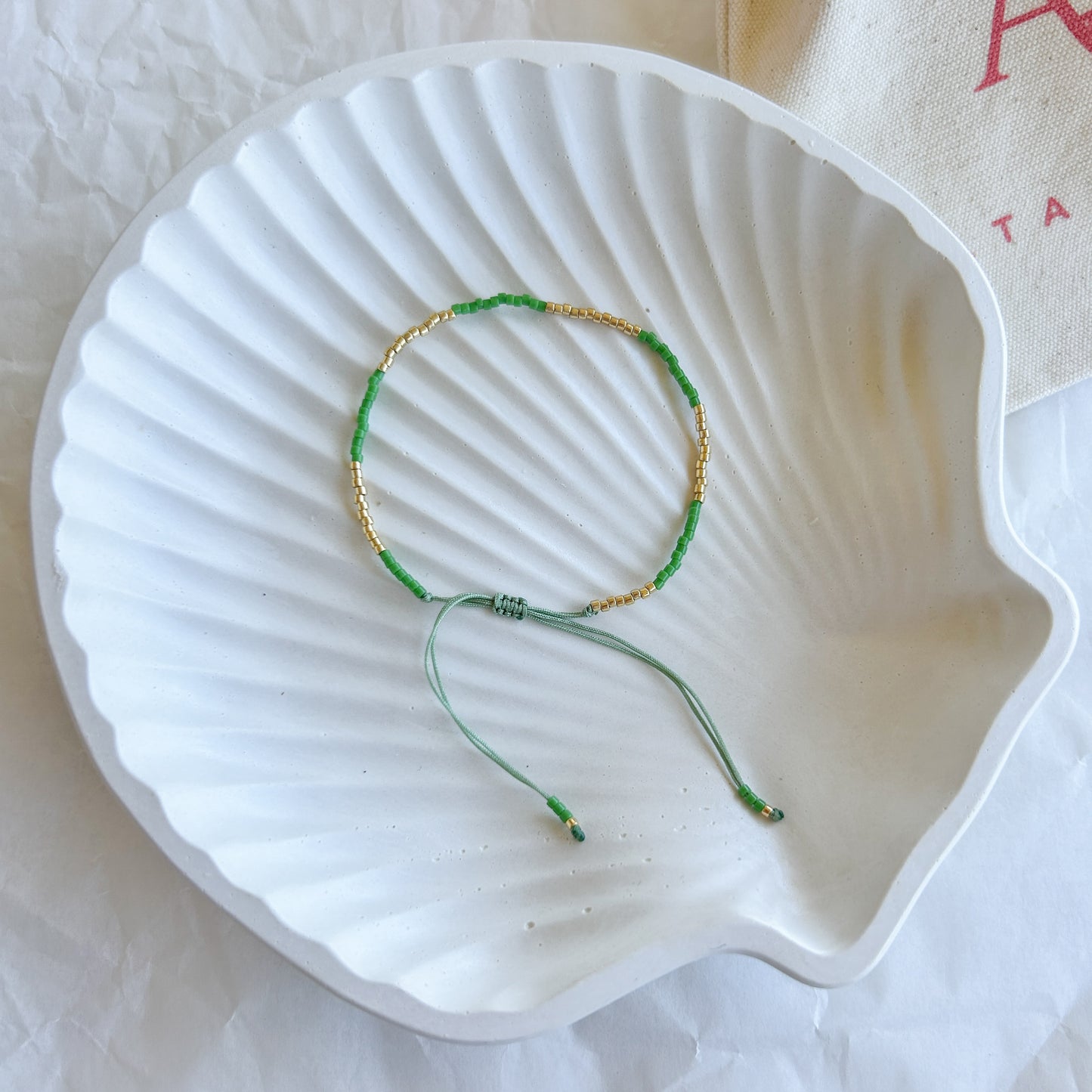 Pulsera artesanal simple Julieta color verde esmeralda con cuentas doradas – Inspirada en la naturaleza, esta pulsera tejida a mano es un accesorio único.