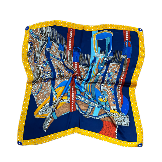 Pañuelo Aloe con diseño artístico, tonos vibrantes de azul y amarillo, confeccionado en símil seda. Accesorio elegante y versátil de 70x70 cm.