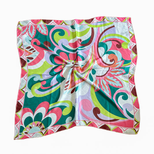 Pañuelo Malva con diseño floral psicodélico en tonos vibrantes como rosa, verde y blanco, confeccionado en símil seda y viscosa, tamaño 70x70 cm.