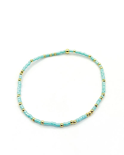 Pulsera artesanal Camila hecha a mano con mostacillas celestes y doradas, diseño minimalista