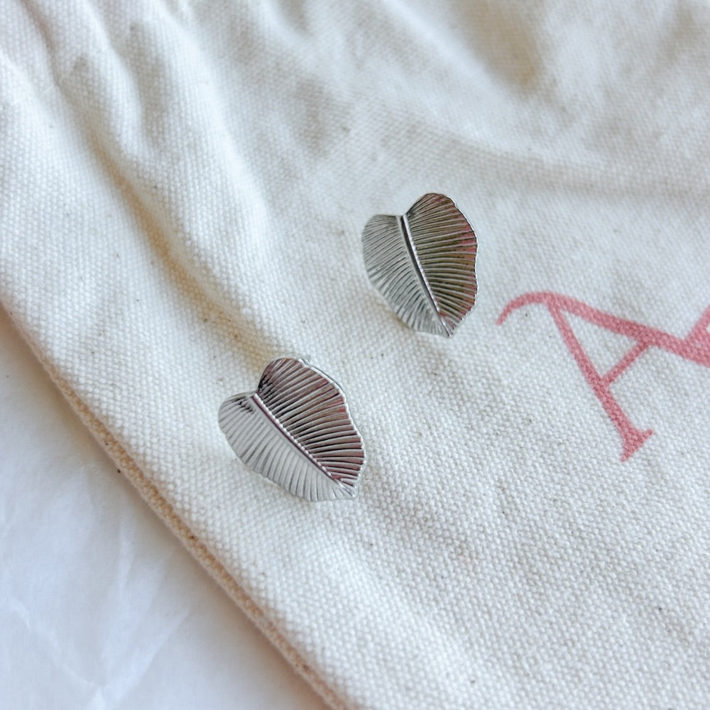 Aros de Plata Hamburgo con diseño en forma de hoja y textura detallada, exhibidos sobre una bolsa de tela Altapinta.