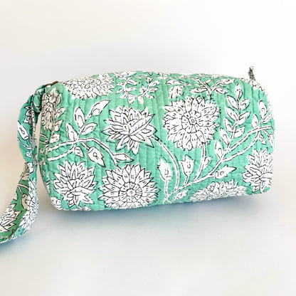 Estuche Amaranto con diseño floral en tonos verdes y blancos sobre fondo claro.