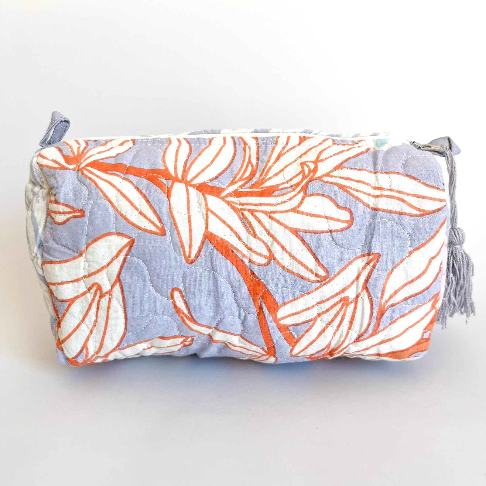Estuche Bergamota acolchado con estampado floral en tonos lavanda y naranja.