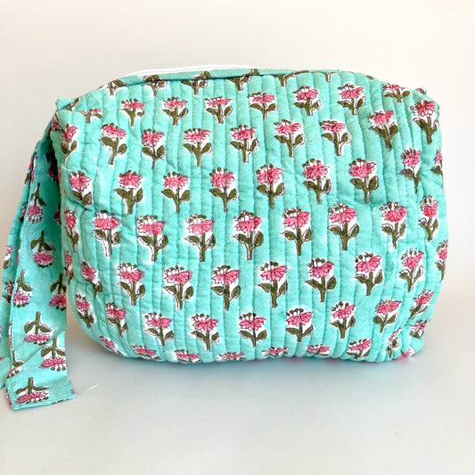Estuche acolchado con estampado de flores rosadas sobre fondo verde menta, ideal para organizar cosméticos y accesorios con estilo.