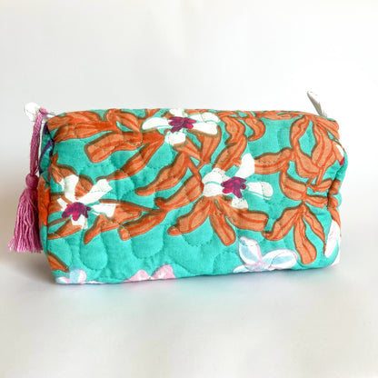 Estuche acolchado con estampado floral en tonos verdes, naranjas y fucsia, con borla decorativa en el cierre